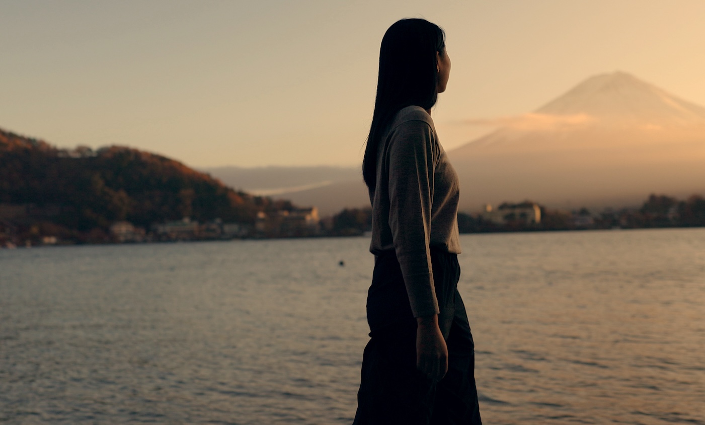 Woman, walking by river and nature with travel and journey outdoor, holiday or vacation with break. Environment, water and fresh air, traveller on adventure with peace, calm and wellness on trip